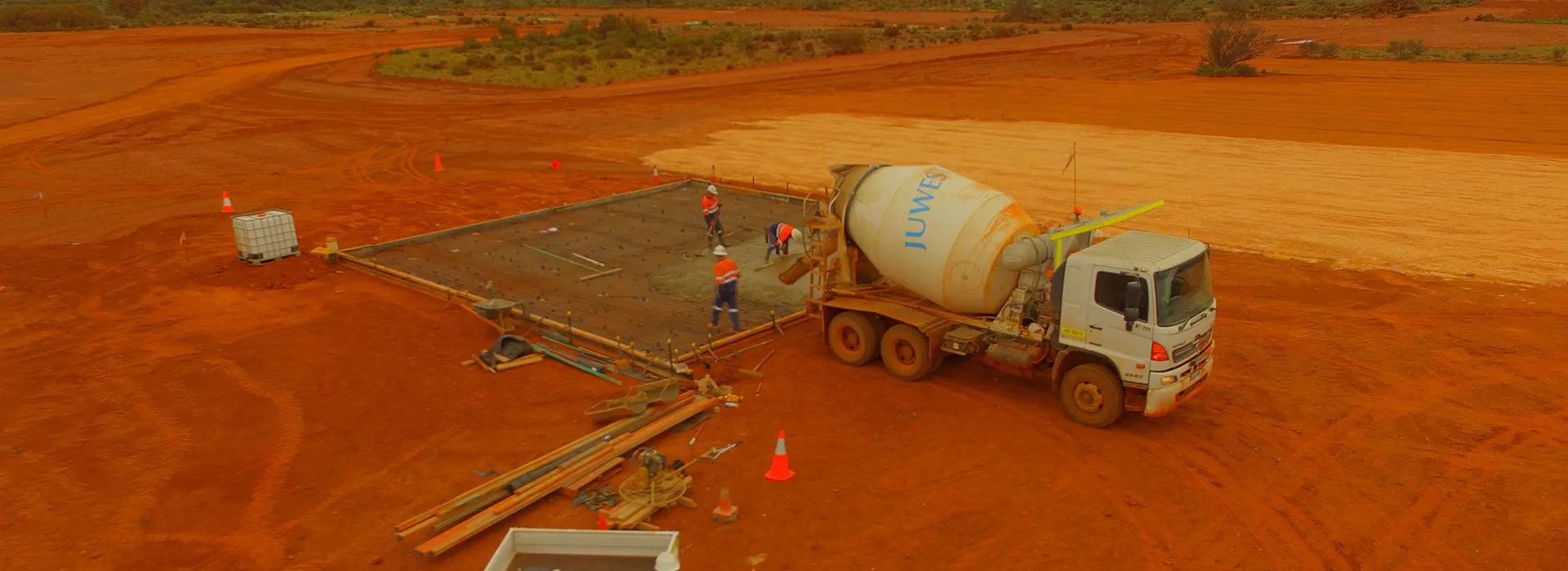 Aerial view of a concrete slab pour on red earth in the Goldfields
