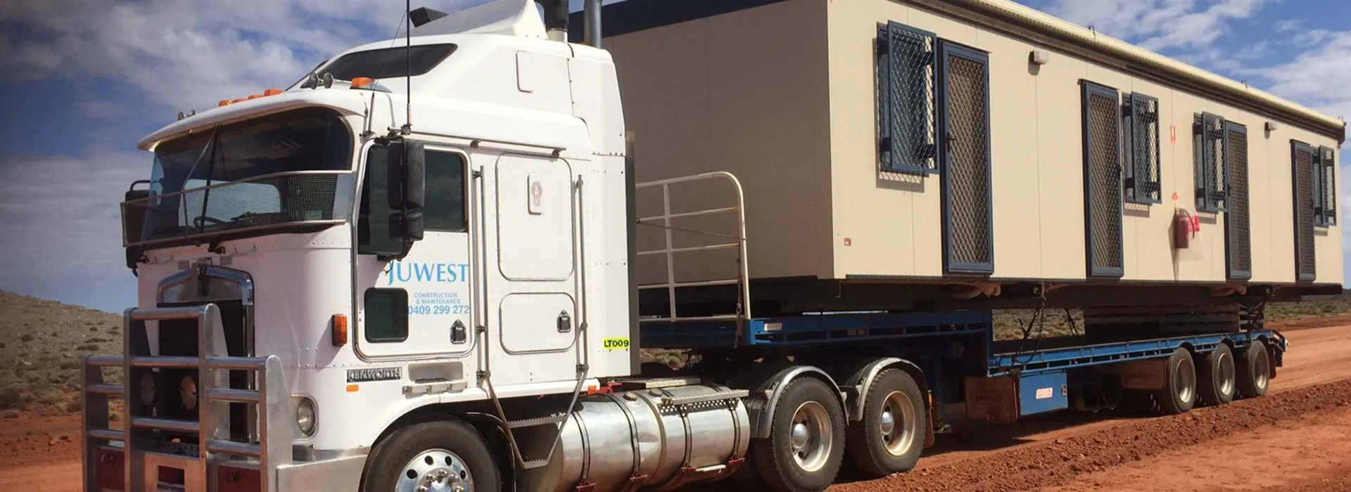 Juwest prime mover hauling a transportable building